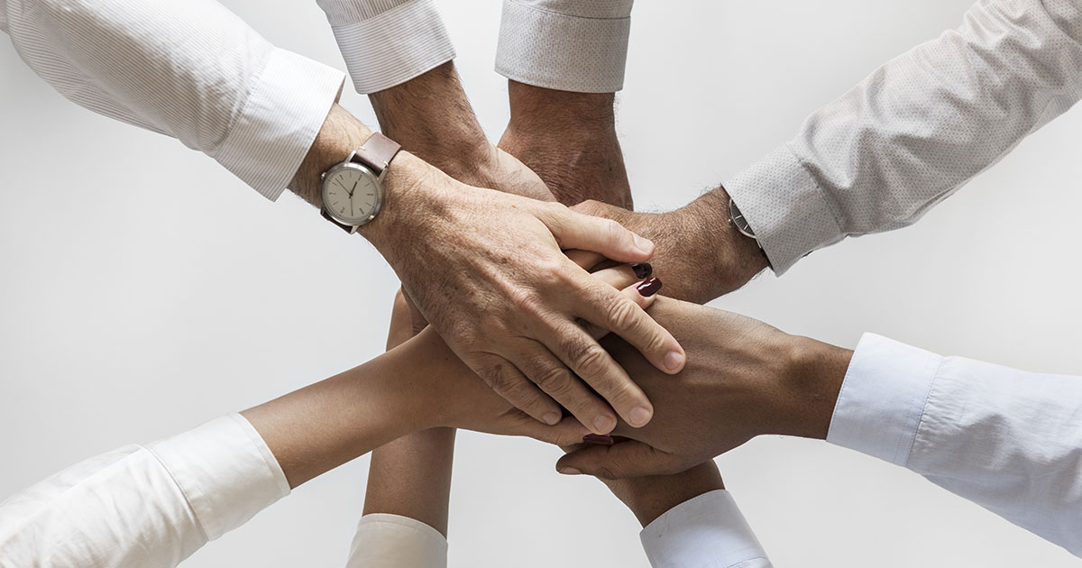 Människor lägger händer över händer