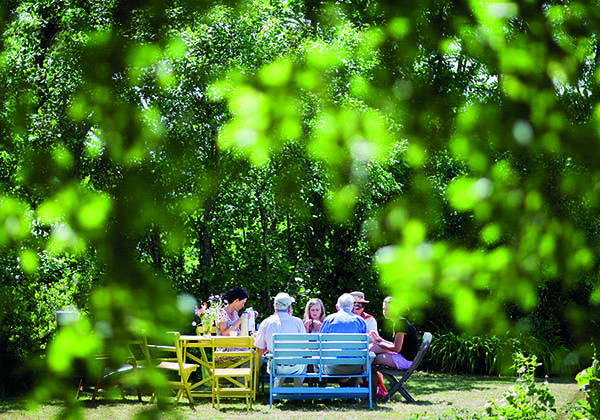 Familj fikar i lummig trädgård