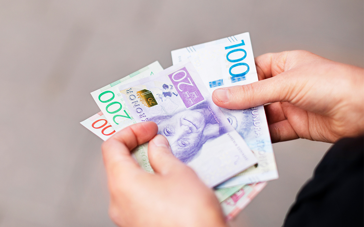 Händer håller i sedlar