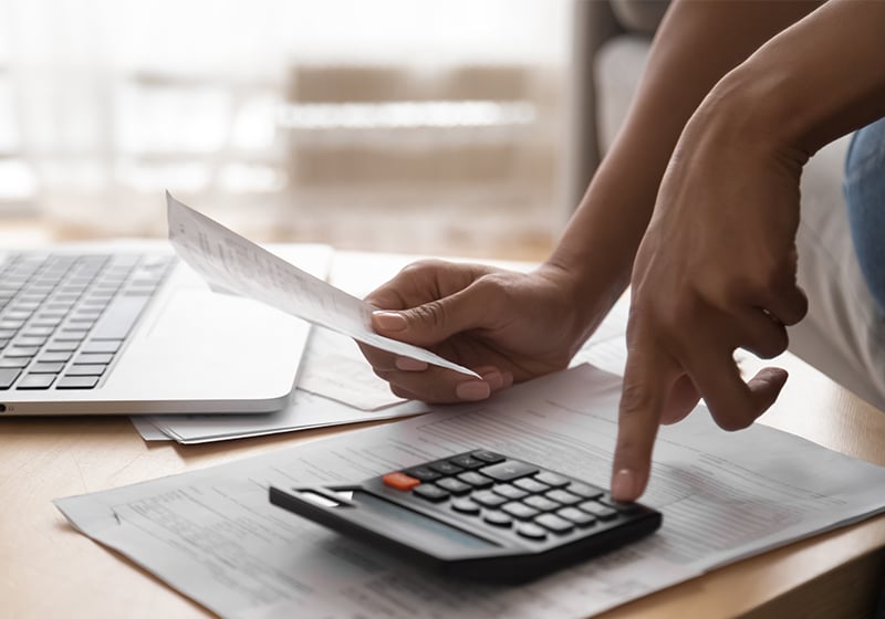 Närbild på kvinnas hand som använder miniräknare