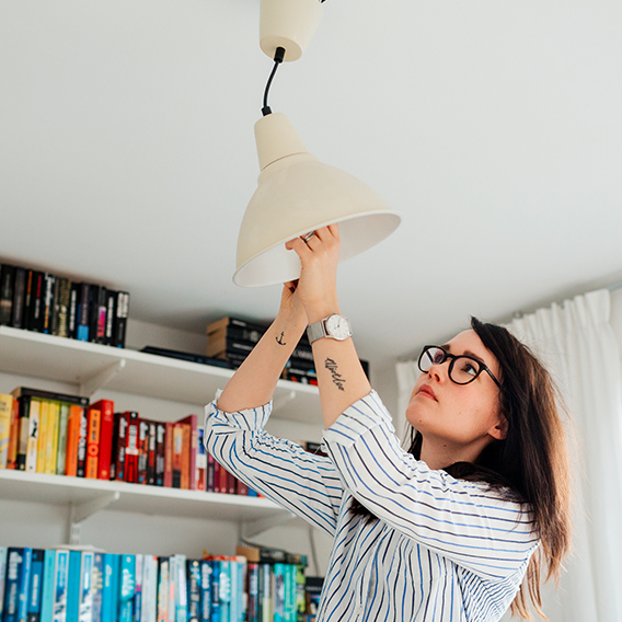 Tjej plockar ut glödlampa