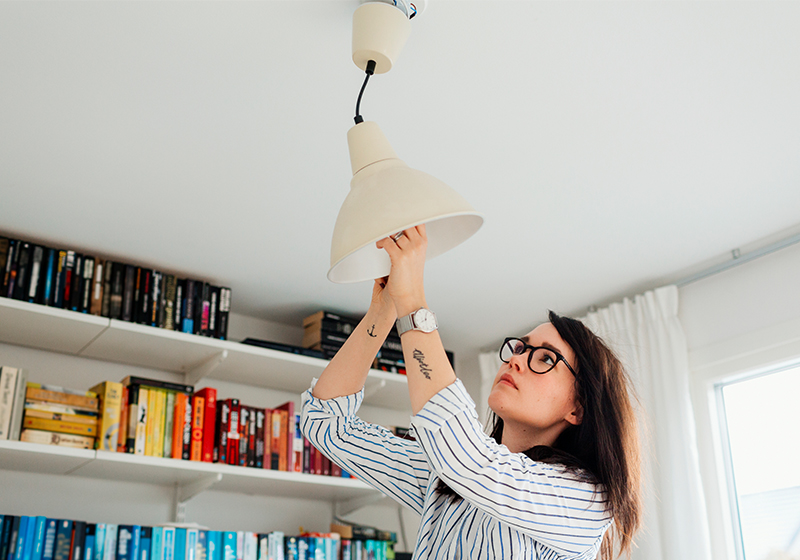 Tjej plockar ut glödlampa