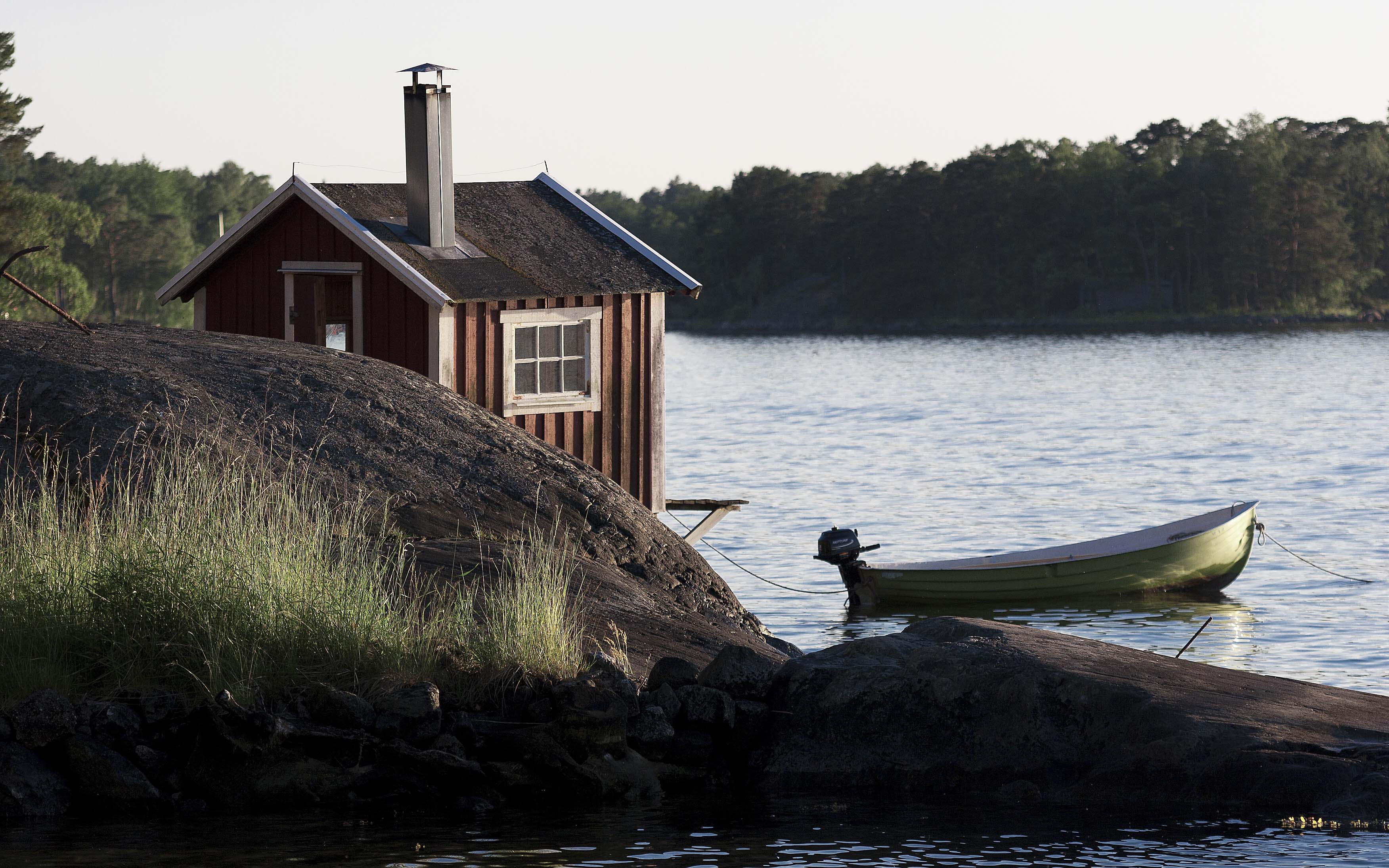 Båthus i skärgården med motorbåt fastsurrad