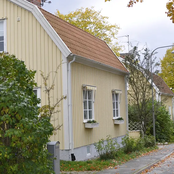 Gult trähus på gata under hösten