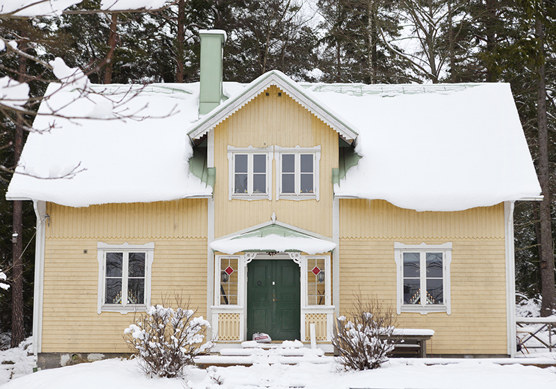 Gammalt gult hus i vinterskrud
