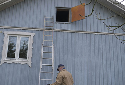 Blått hus med stege upp till öppen kallvind