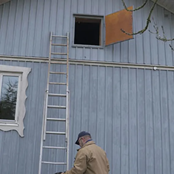 Blått hus med stege upp till öppen kallvind