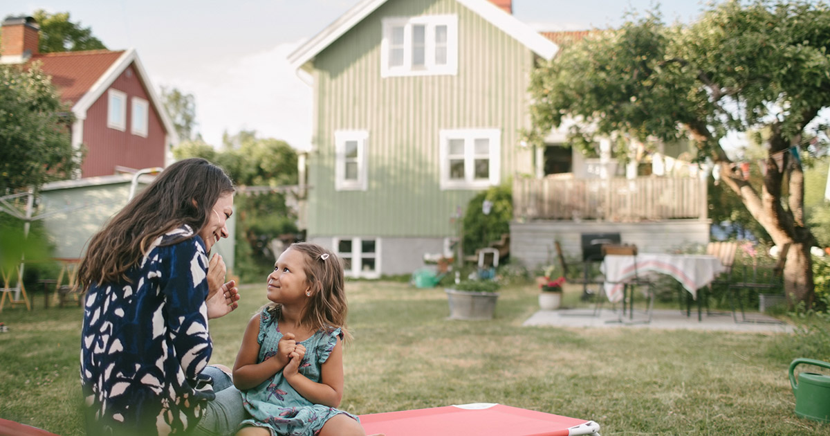 Mor och dotter på tomt utanför hus