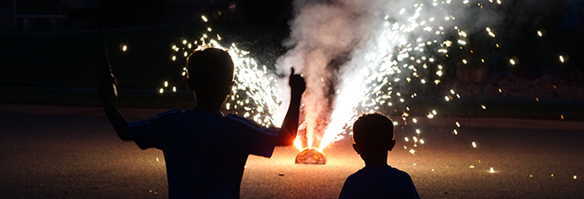Siluettbild av två barn som tittar på fyrverkeri