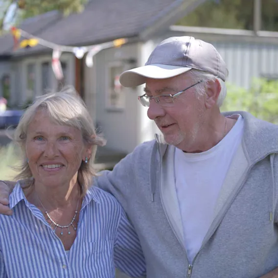 Glada pensionärer håller om varandra