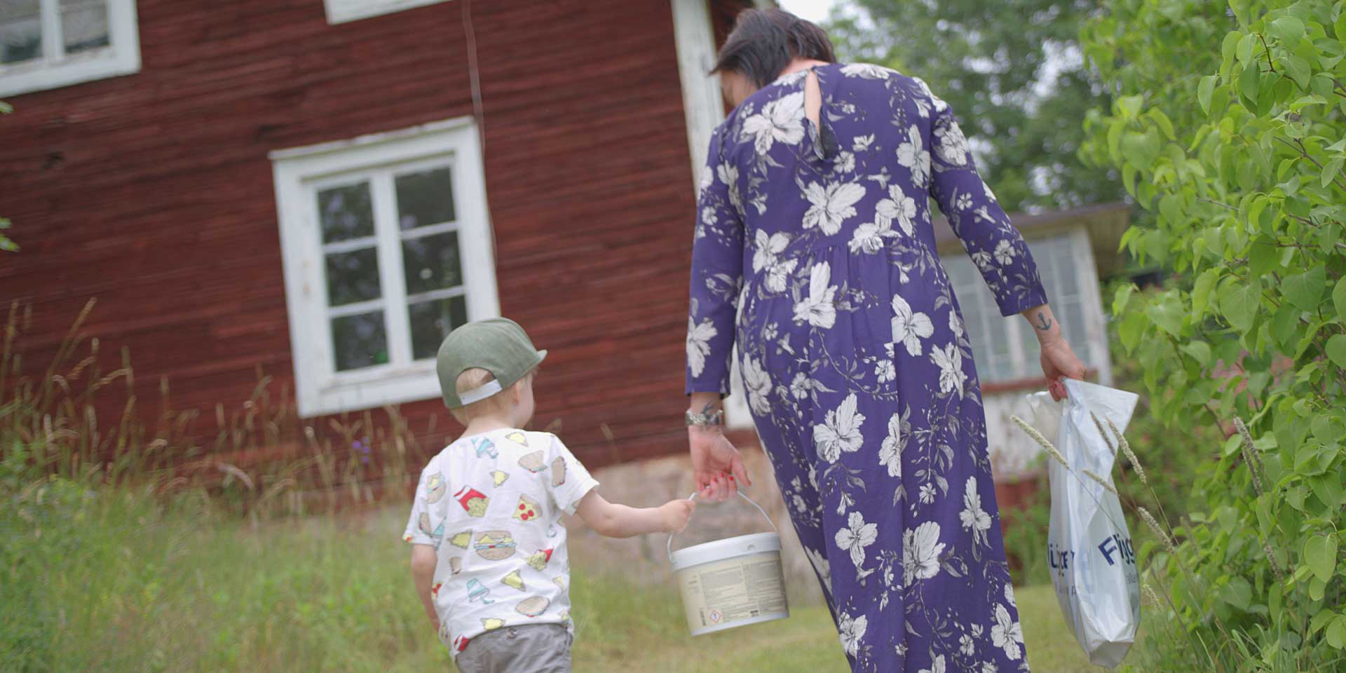 Mamma och son bär färgburk tillsammans